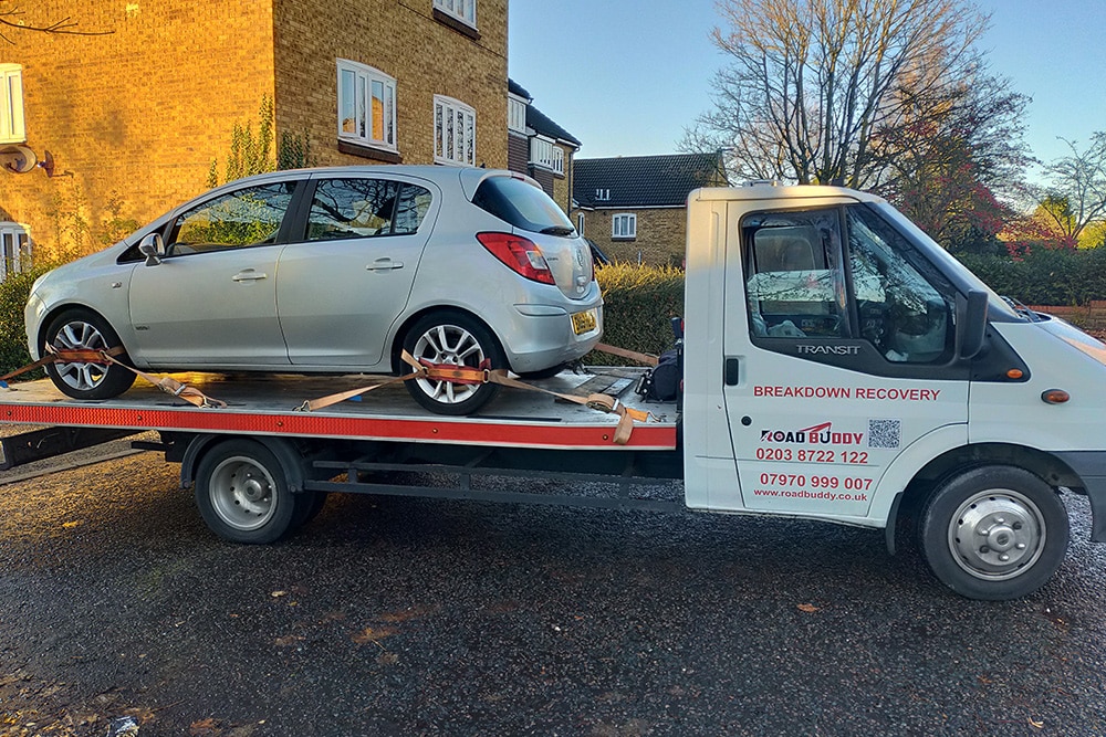 Recovery truck loading broken down car from roadside during emergency service